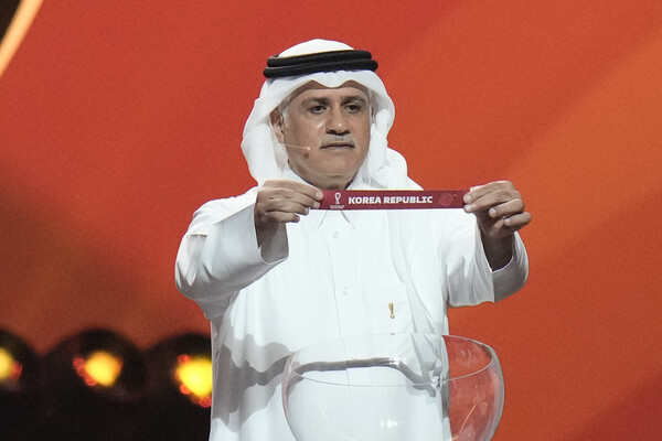 2일 오전(한국시간) 카타르 도하에서 열린 2022 월드컵 조 추첨식에서 카타르 축구 대표 출신 아델 아흐메드 말알라가 한국이 표기된 쪽지를 들어 보이고 있다. [AP=연합뉴스]