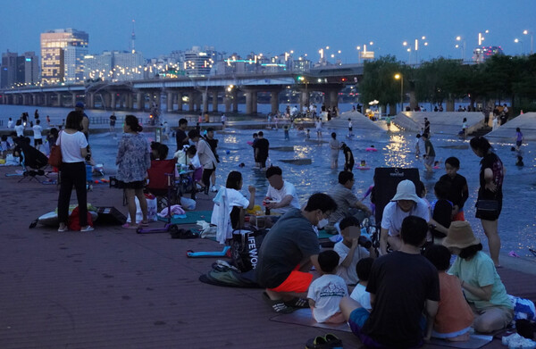 지난 3일 밤 서울 영등포구 여의도한강공원 물빛광장에서 시민들이 여가를 보내고 있다. [연합뉴스]