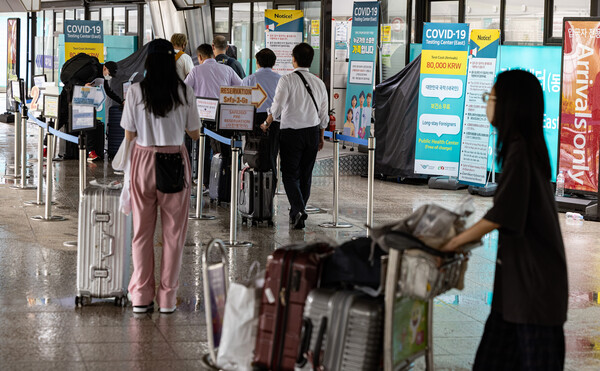 지난 4일 오후 인천국제공항을 통해 입국한 외국인 여행객들이 코로나19 검사를 받기 위해 공항 내 검사소에서 대기하고 있다. [연합뉴스]